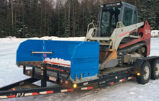 Snowplow with a skidsteer on a trailer.